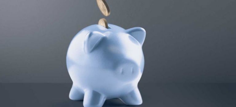 Blue piggy bank with coins going in