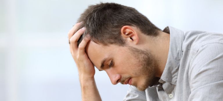 Man with head in hand looking sad