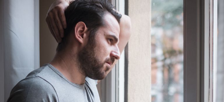 Man looking out window