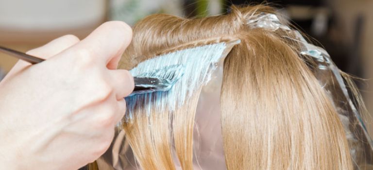 Woman getting hair coloured at hairdresser
