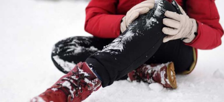 Woman holding knee having slipped on ice