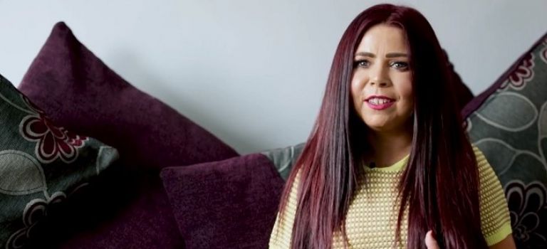 Jacqui Mills sitting on couch at home