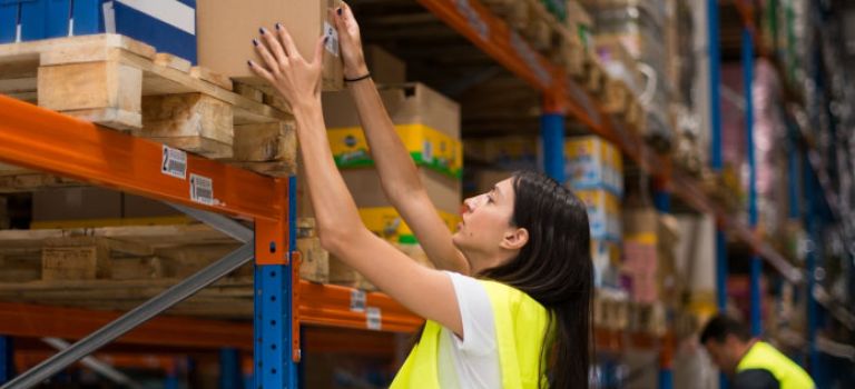 Warehouse worker getting a package from shelf