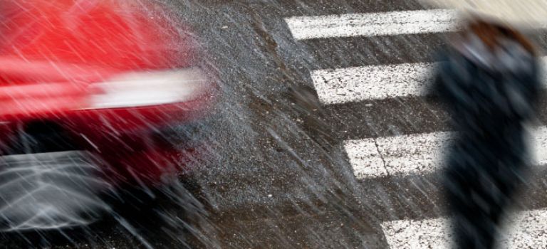 Pedestrian crossing road in rain