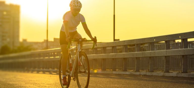 Woman cycling along road