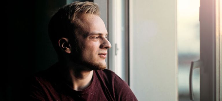 Man looking out window