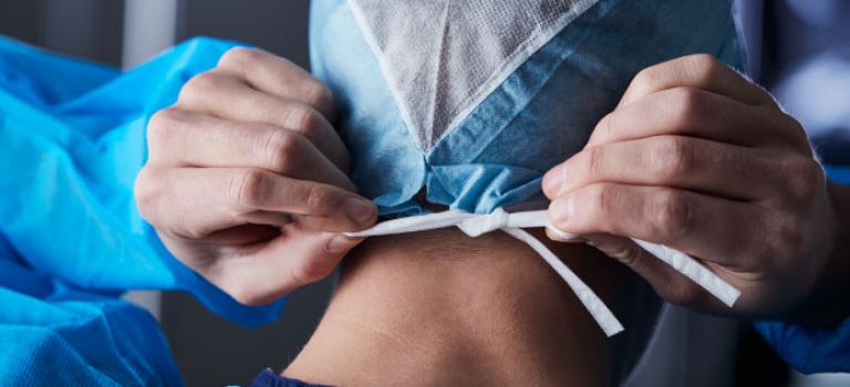 Surgeon tying mask before surgery