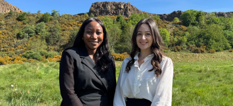 Theresa Mutapi and Rona Hayworth (Digby Brown's newly promoted Partners) standing at the base of Arthur's Seat in Edinburgh