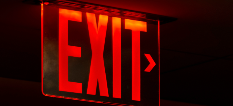 Red exit sign on a dark background