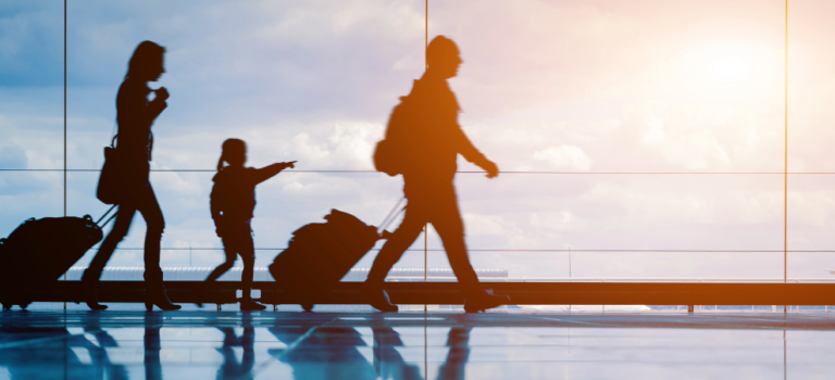 Three people walking with suitcases in an airport