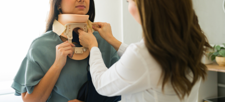 A health professional securing a neck brace on a woman.
