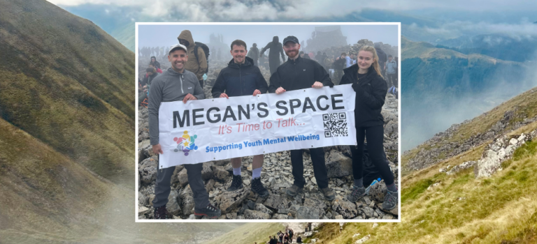Four colleagues from our Ayr office pictured at the summit of Ben Nevis holding a banner for their local office charity Megan's Space