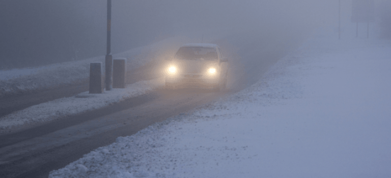 Car driving in the snow and fog