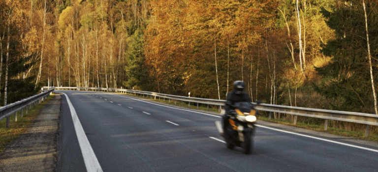 Biker riding motorbike in Autumn