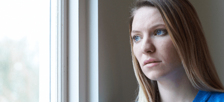 Woman looking sad at window