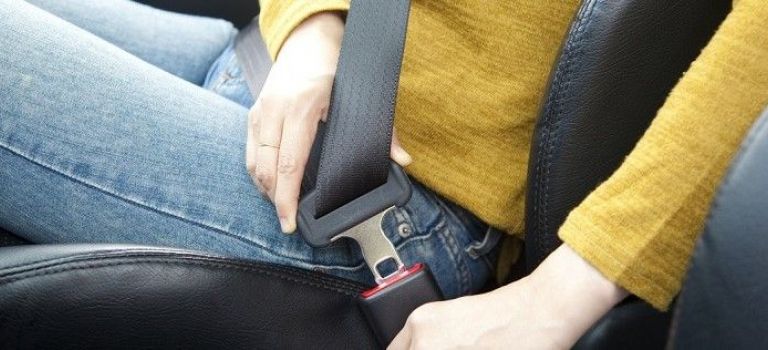 Woman putting on seatbelt