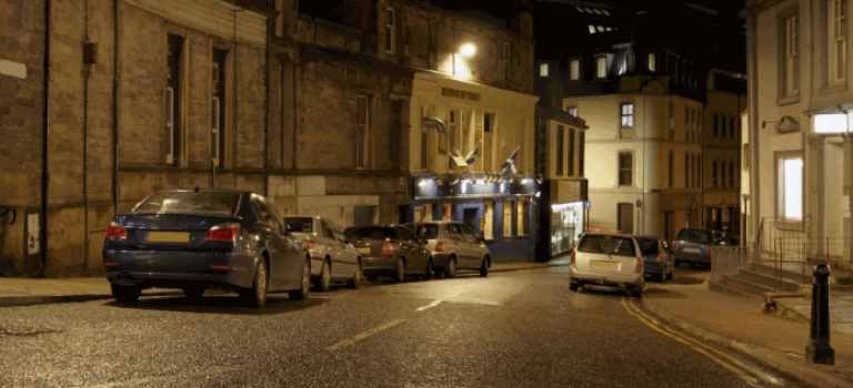 parked cars in the road at night